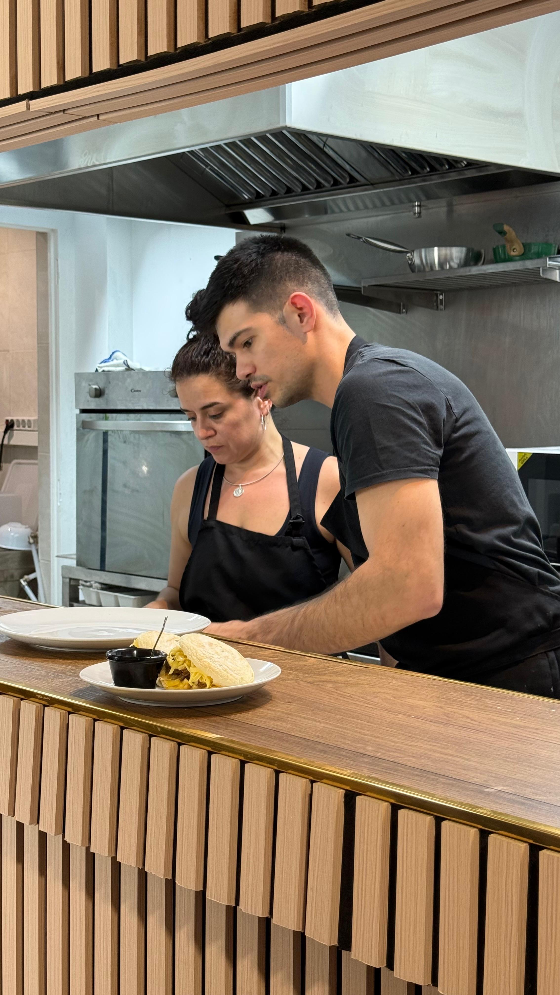 Dos miembros del equipo de Tierra de Todos cocinando juntos en la cocina